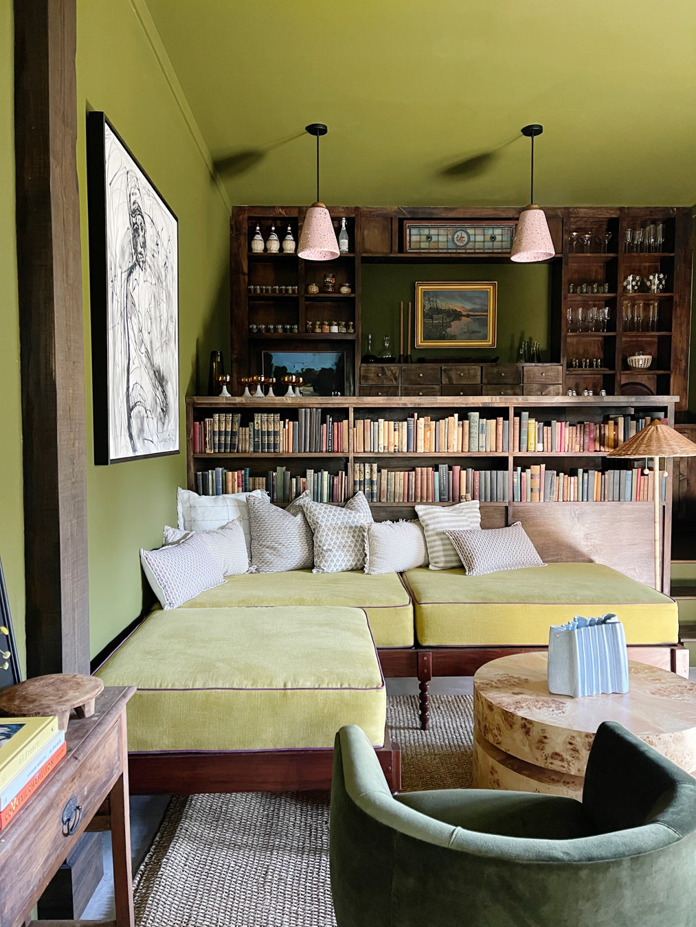 Living room with a yellow sofa, bookshelves, and decorative items.