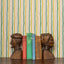 Wooden bookends shaped like human heads with a row of books against a chartreuse and green striped wallpaper background