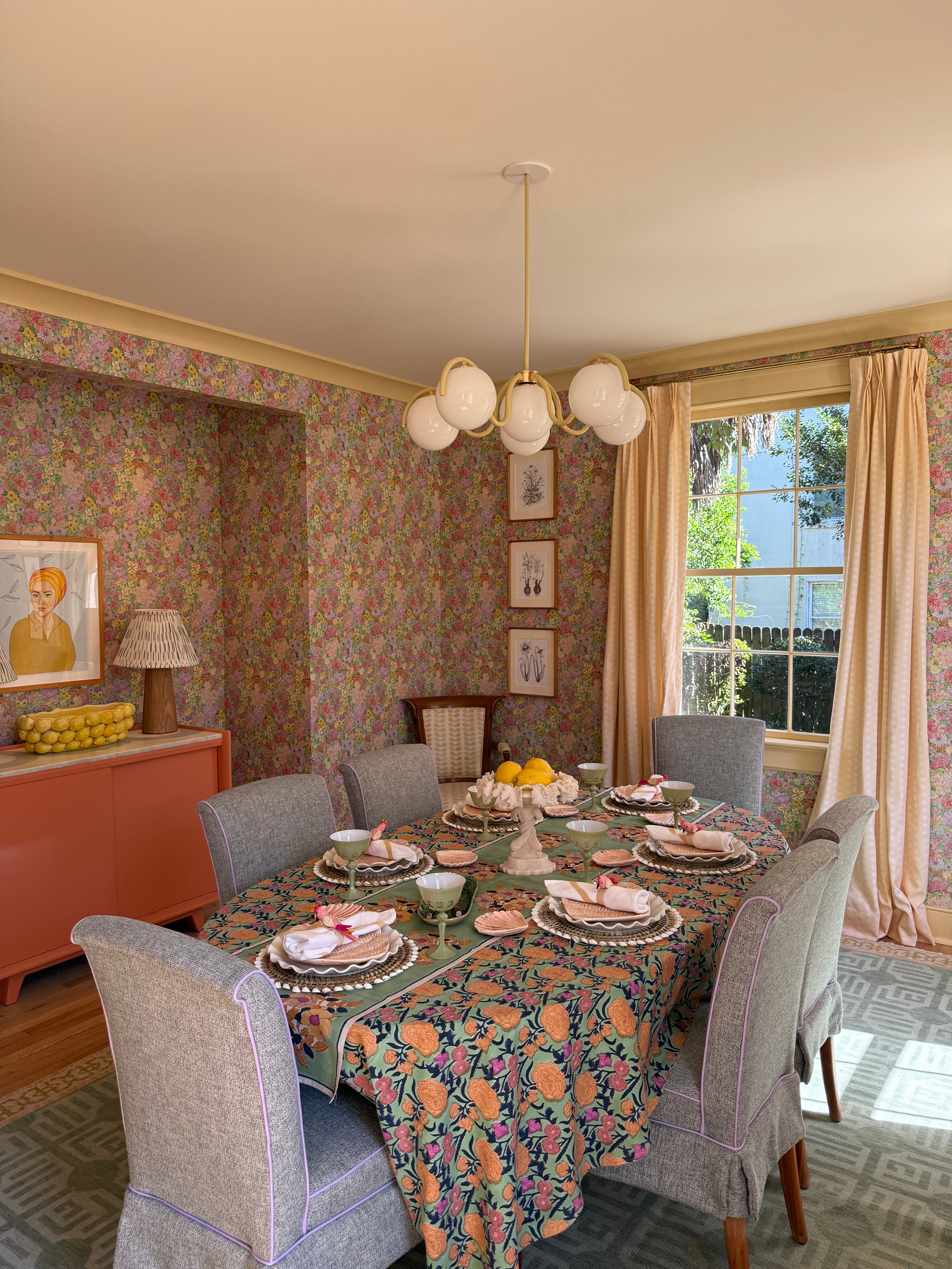 Dining room with floral wallpaper, a window, and decorative items.