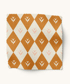 Fabric swatch with floral orange and white diamond pattern on a white background