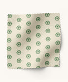 Fabric swatch with green floral pattern on a beige background