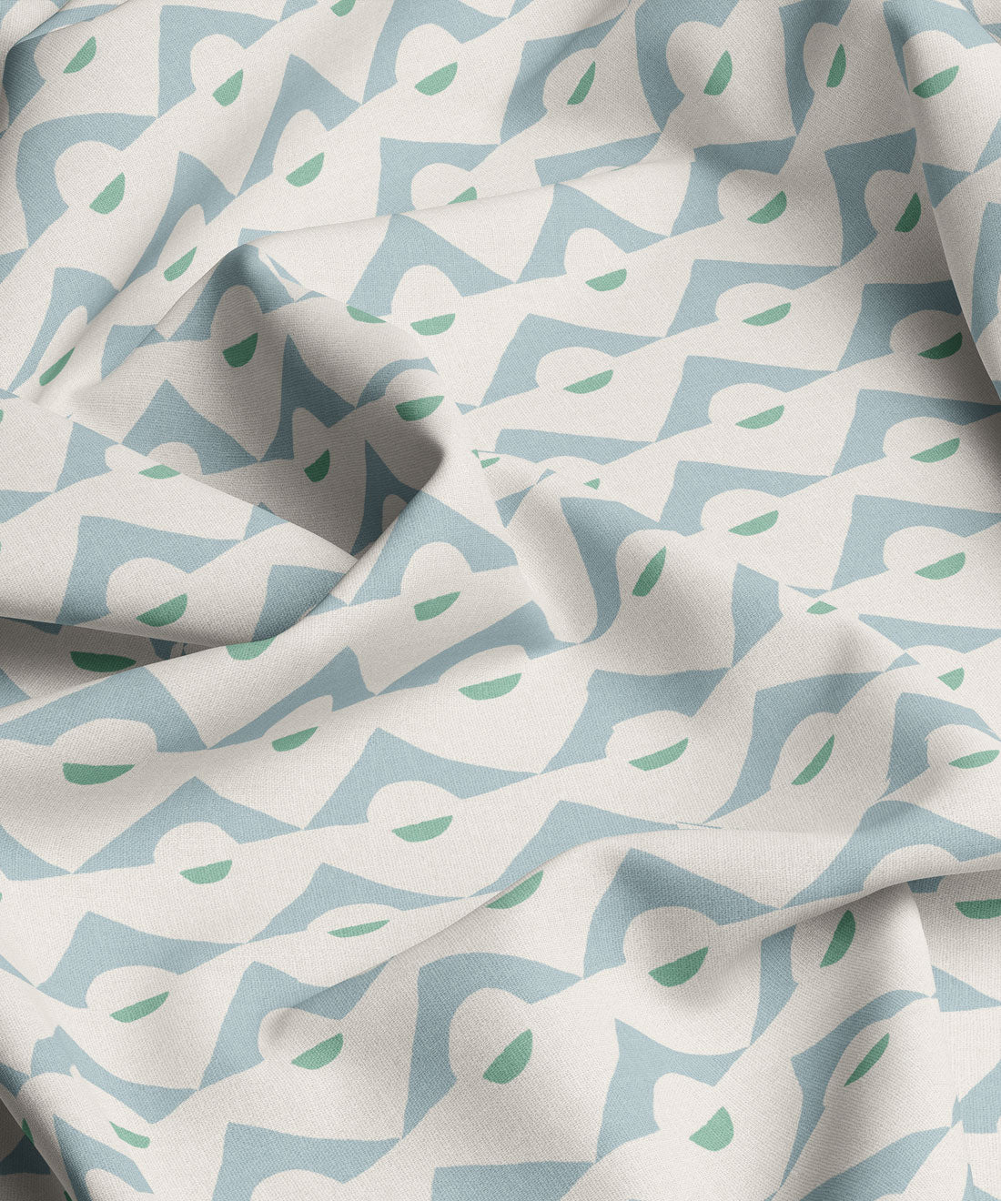 Fabric with a pattern of blue and green shapes on a white background