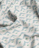 Fabric with a pattern of blue and green shapes on a white background