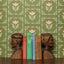 Wooden bookends with books on a surface against a floral-patterned green background
