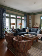 Blue and green Living room with a couch, coffee table, and large windows.