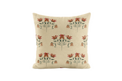 Decorative pillow with red and green floral pattern on a beige background