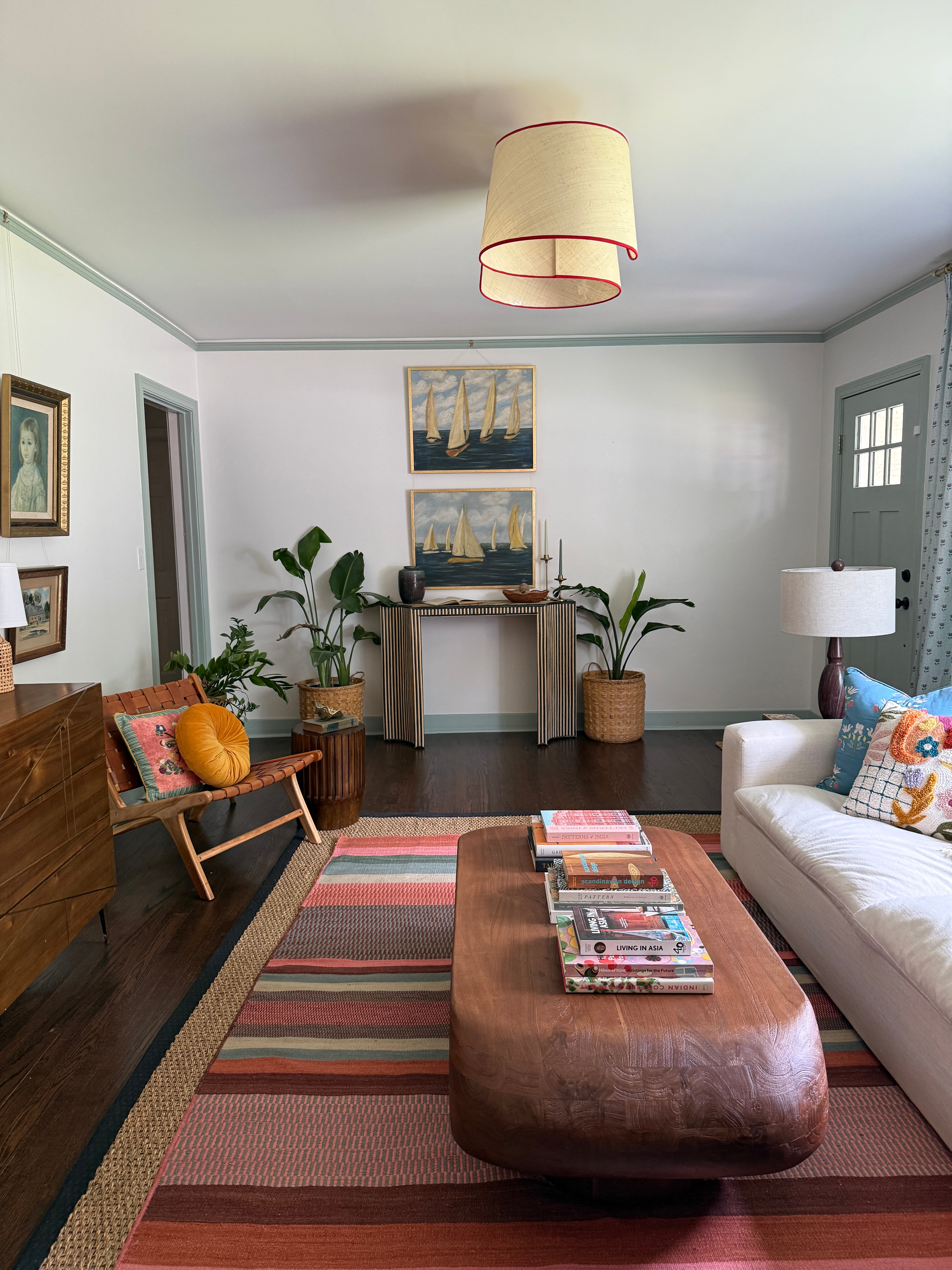 Living room designed by Gray Benko Home with a brown leather sofa, wooden coffee table, and decorative items.