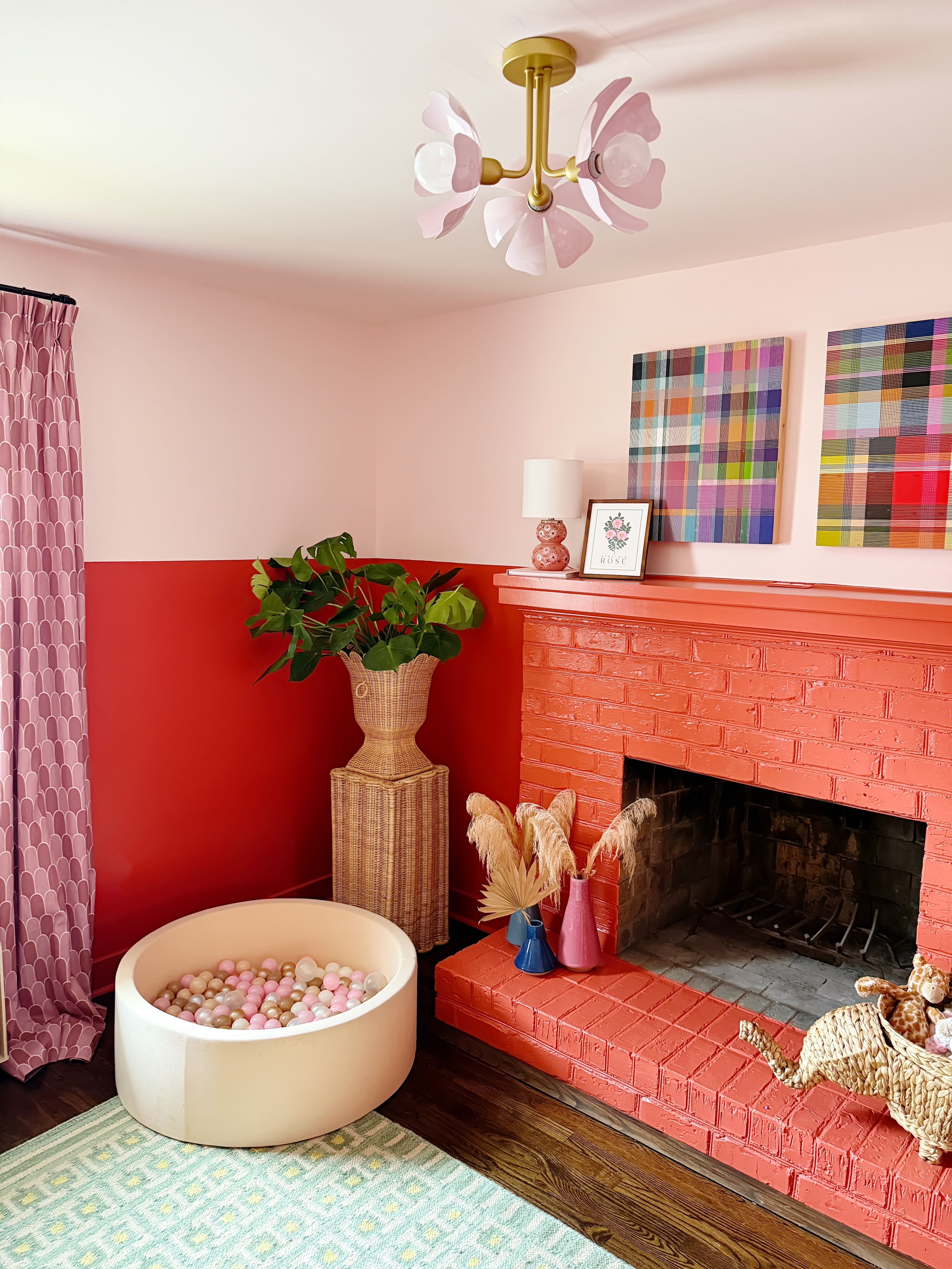 play room with a red fireplace, pink walls, and decorative elements.