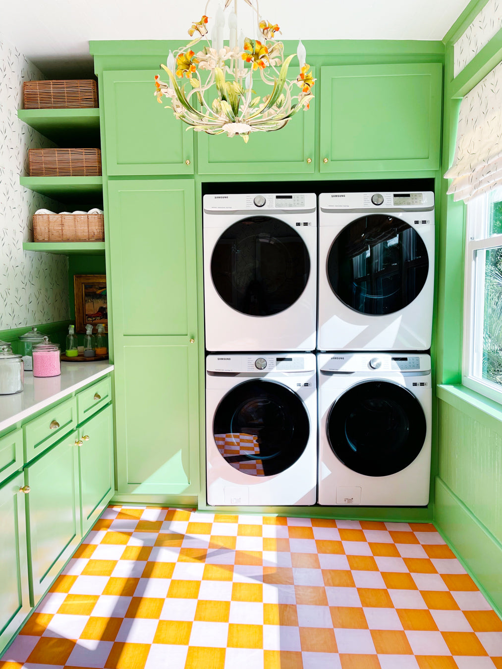 Green laundry room with stacked washer and dryer against a green wall.
