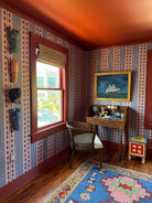 Boys room with striped red and blue wallpaper and red trim