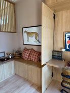 Wooden desk area with a leopard painting on the wall.