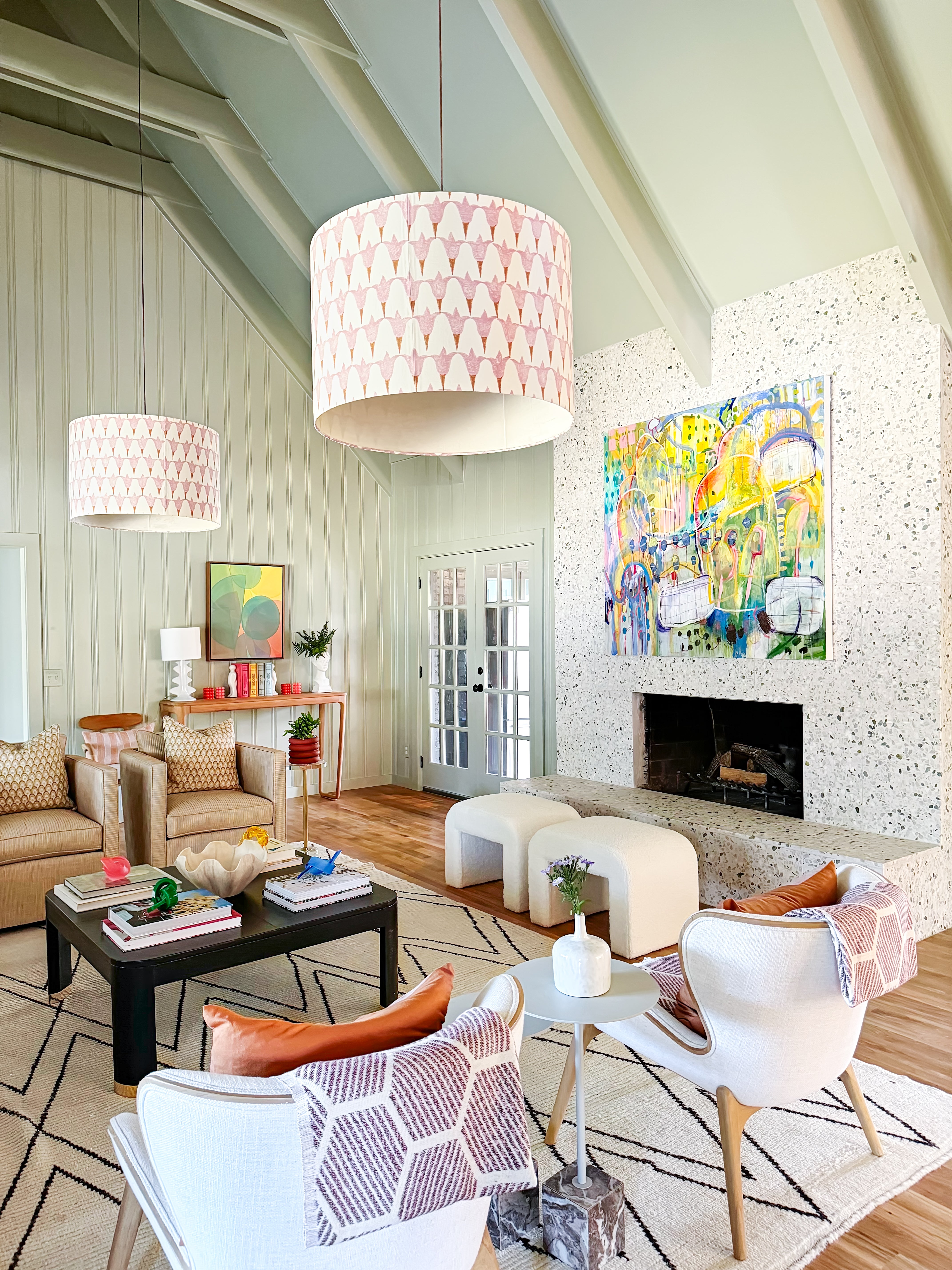 Modern living room with colorful artwork, comfortable furniture, and decorative elements.