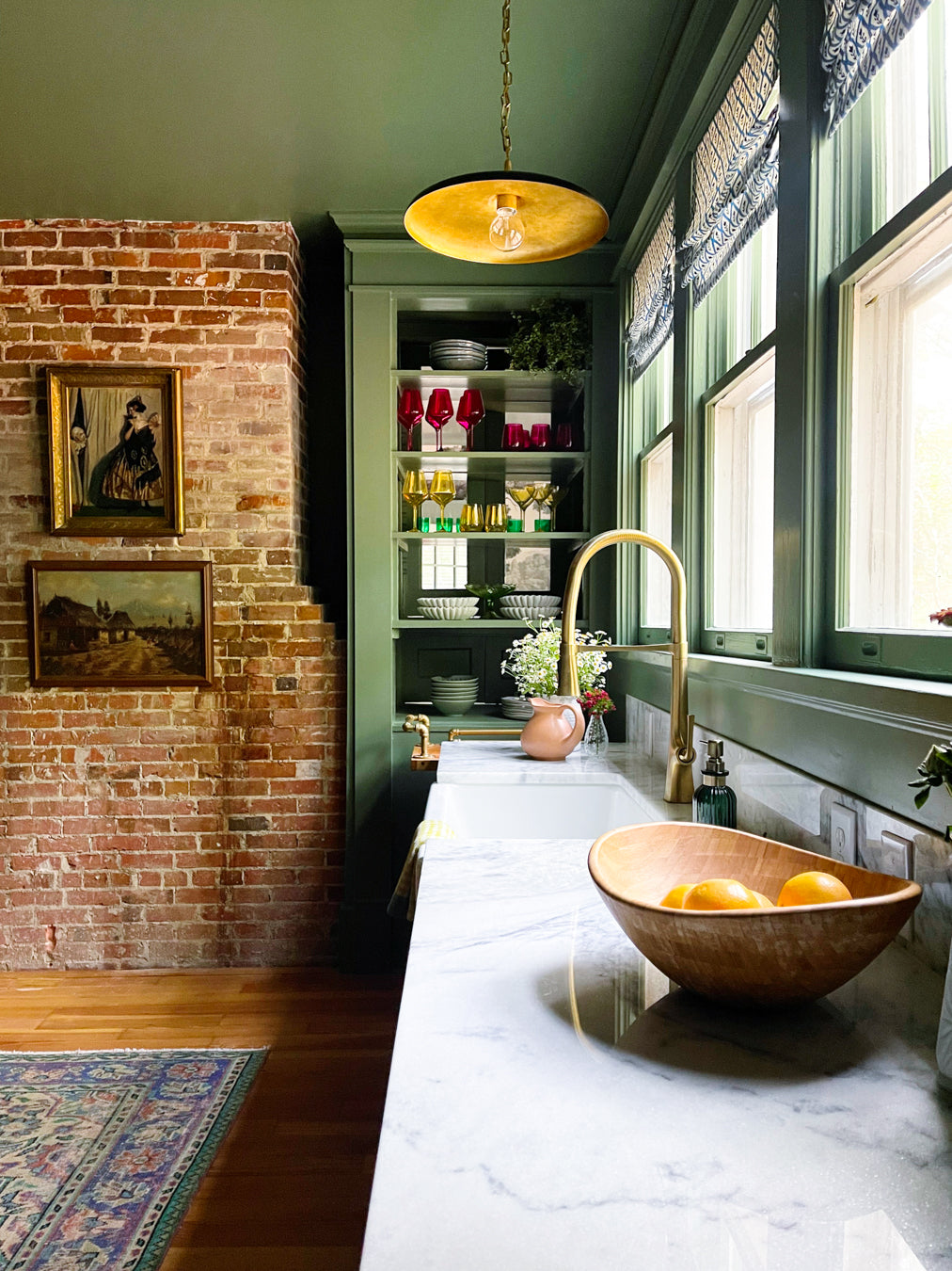 dark green, Modern kitchen with marble countertop, brick wall, and large window.